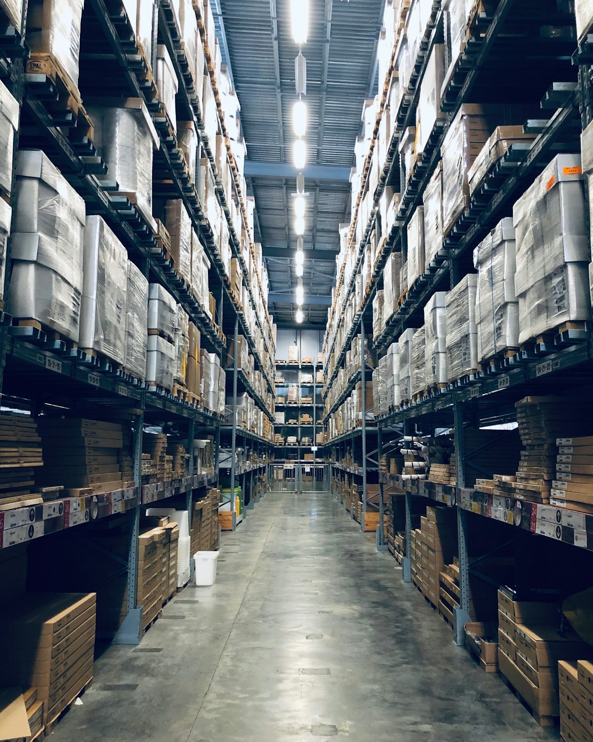 Pasillo de un almacén con estanterías llenas de palés